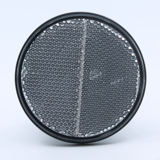 Reflector de seguridad de forma redonda y color blanco, para montaje frontal con fijación adhesiva, utilizado en remolques y maquinaria agrícola.