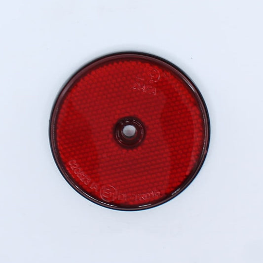 Reflector de seguridad de forma redonda y color rojo, con fijación de atornillar, utilizado como señalización trasera en remolques y maquinaria agrícola.