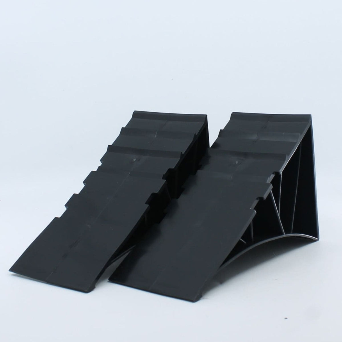 Juego de 2 calzos plásticos de estacionamiento para remolque con soportes de fijación y tornillería de montaje.
