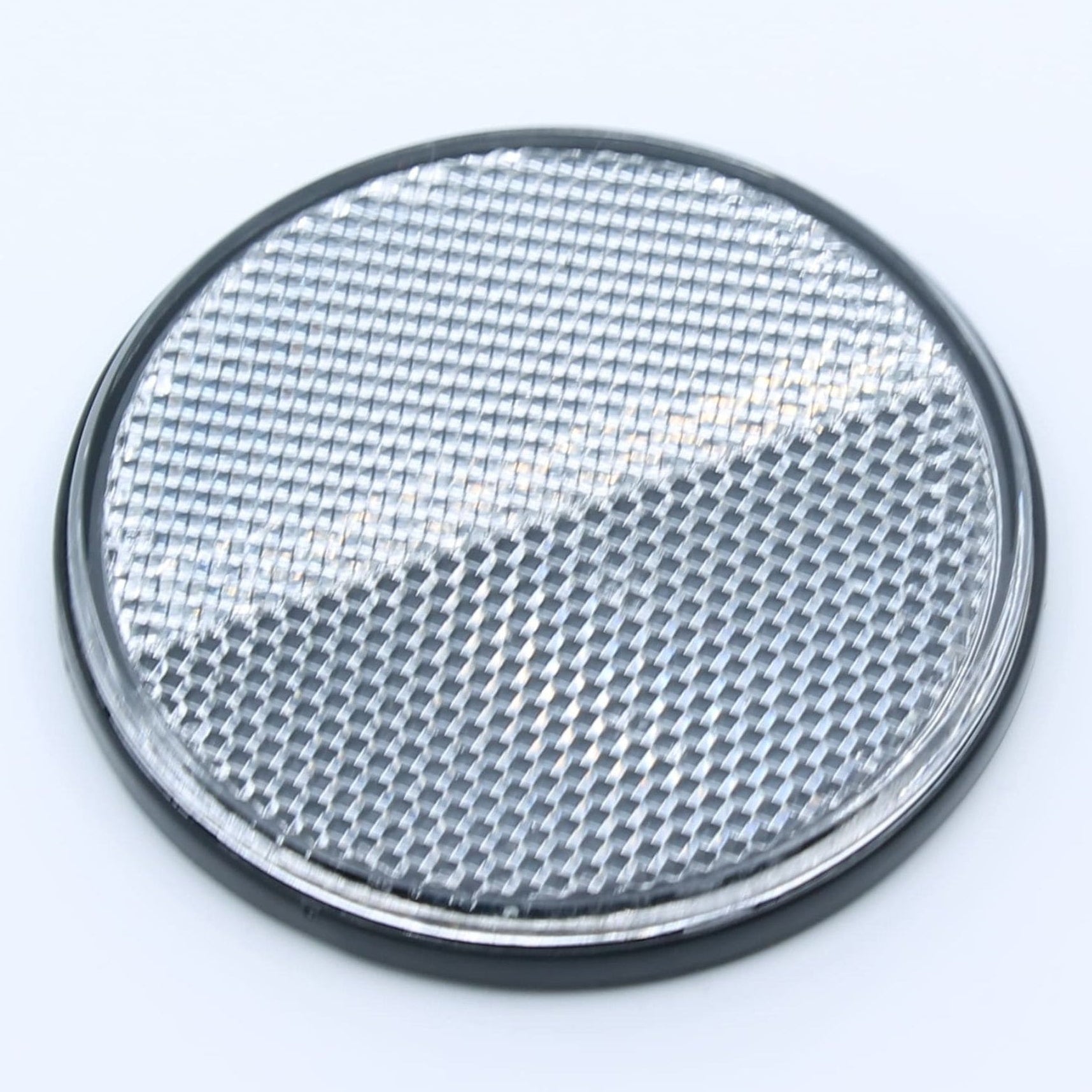 Reflector de seguridad de forma redonda y color blanco, para montaje frontal con fijación adhesiva, utilizado en remolques y maquinaria agrícola.