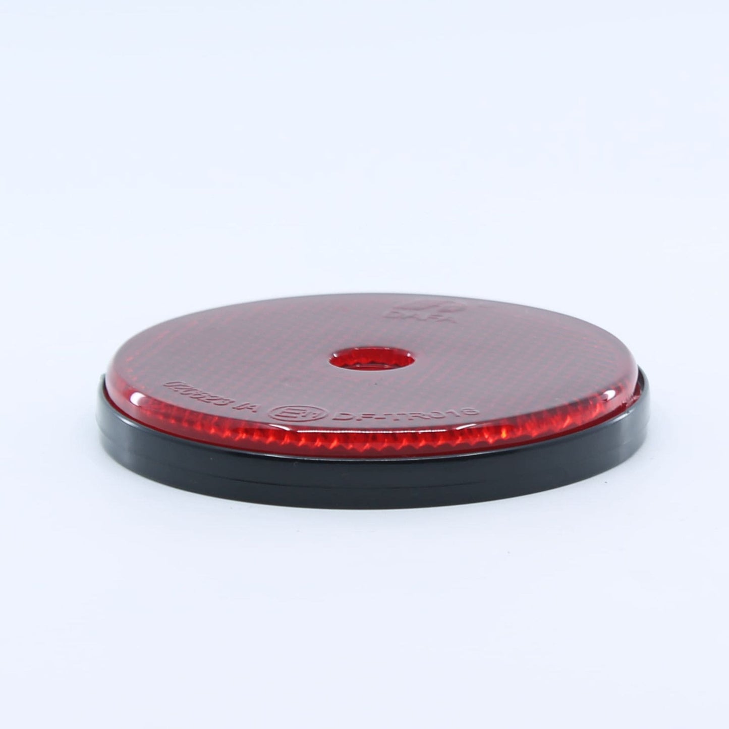 Reflector de seguridad de forma redonda y color rojo, con fijación de atornillar, utilizado como señalización trasera en remolques y maquinaria agrícola.