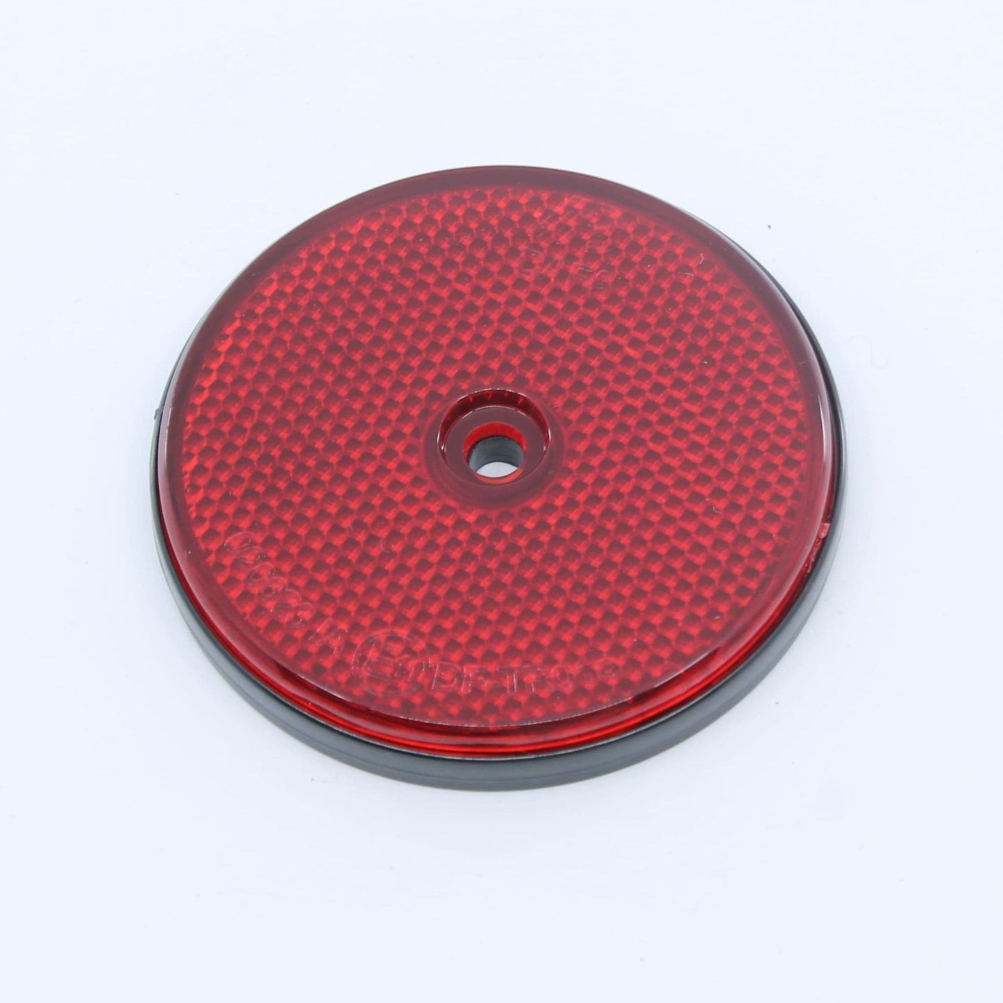 Reflector de seguridad de forma redonda y color rojo, con fijación de atornillar, utilizado como señalización trasera en remolques y maquinaria agrícola.
