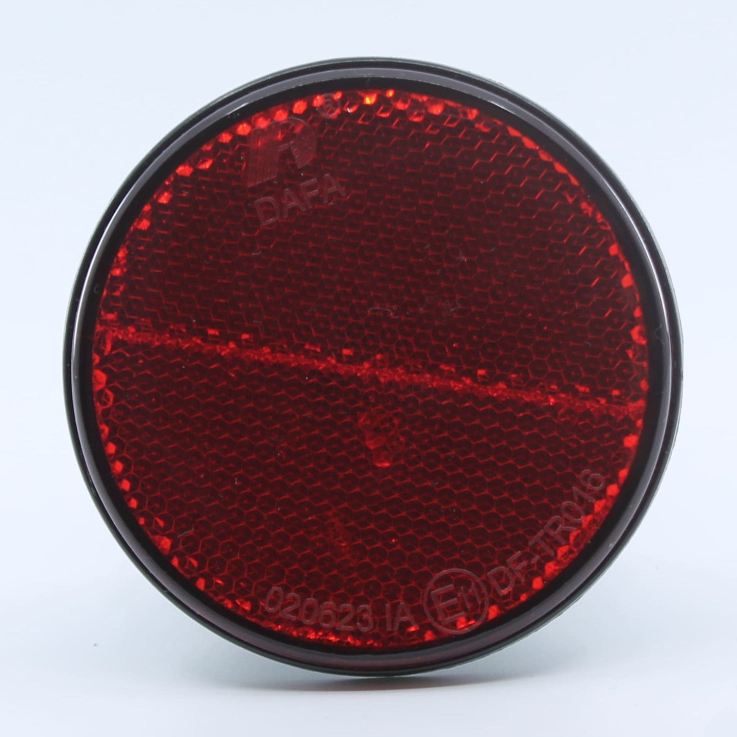 Reflector de seguridad de forma redonda y color rojo, para montaje trasero con fijación adhesiva, utilizado en remolques y maquinaria agrícola.