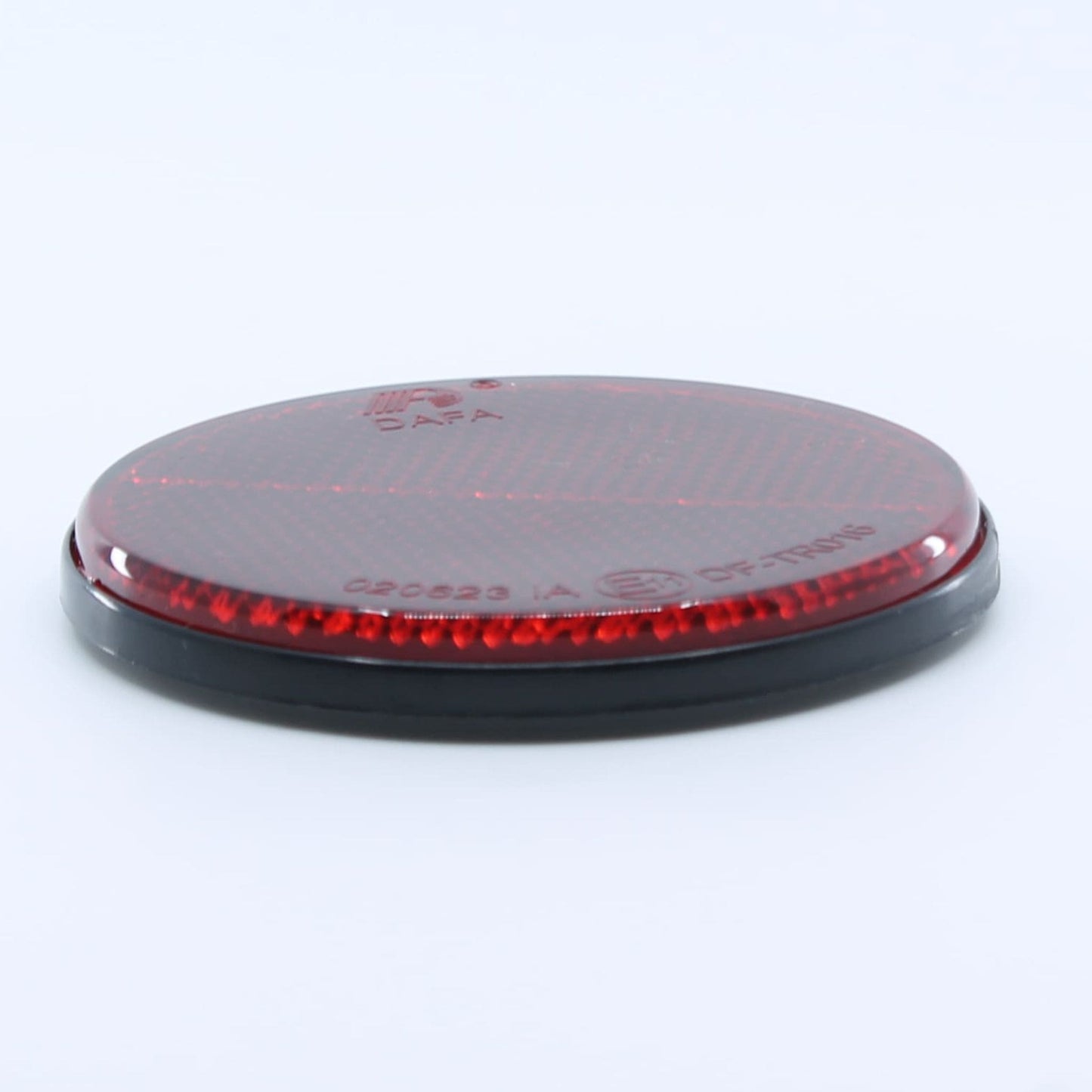 Reflector de seguridad de forma redonda y color rojo, para montaje trasero con fijación adhesiva, utilizado en remolques y maquinaria agrícola.