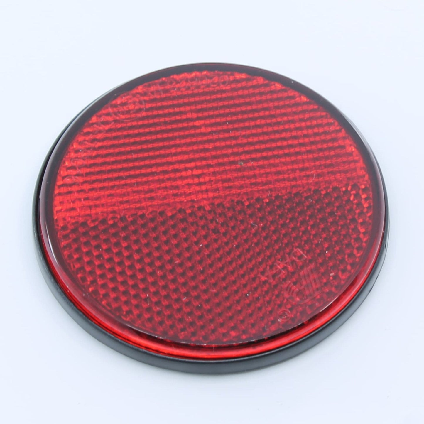 Reflector de seguridad de forma redonda y color rojo, para montaje trasero con fijación adhesiva, utilizado en remolques y maquinaria agrícola.