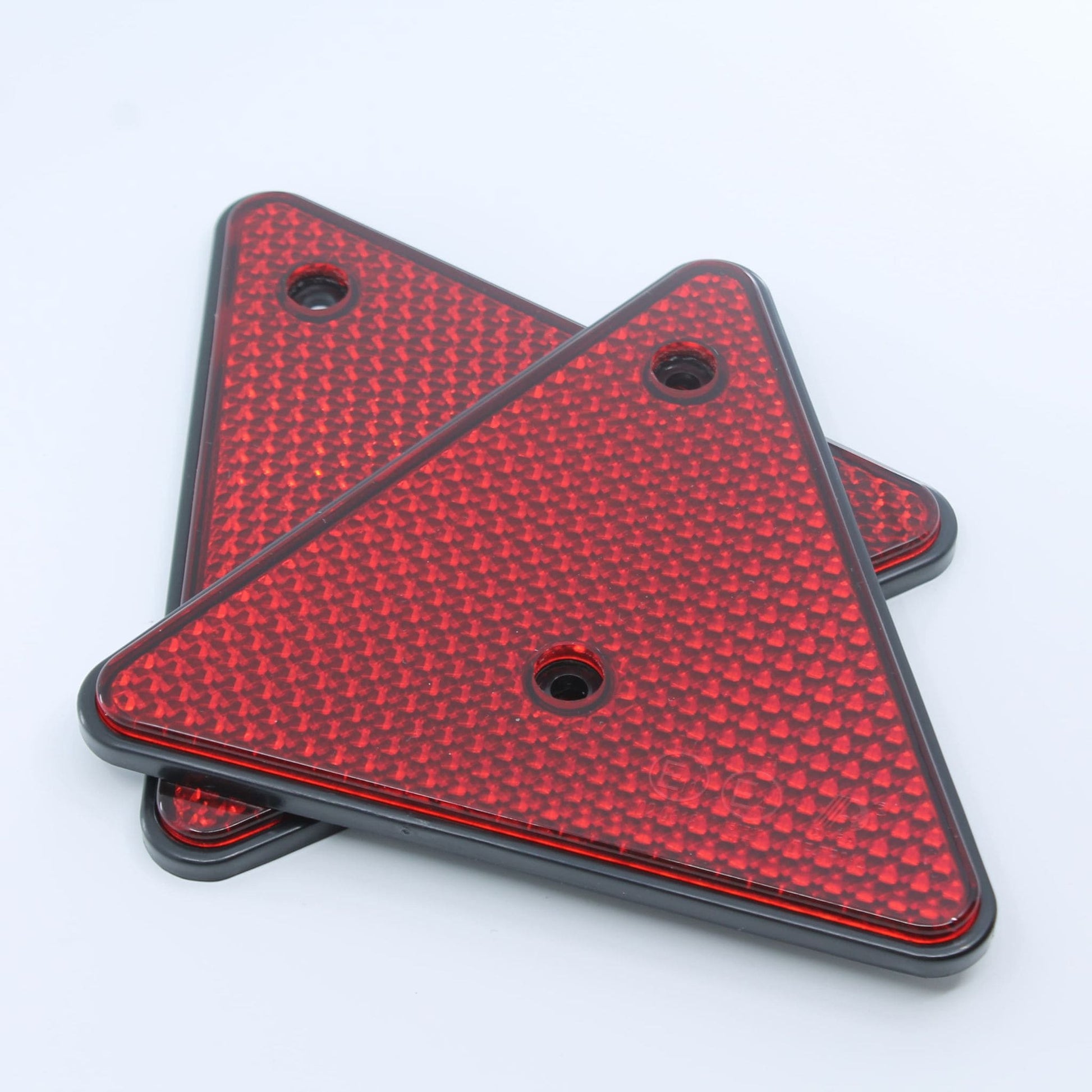 Reflector de seguridad de forma triangular y color rojo, con fijación de atornillar, obligatorio para remolques y maquinaria agrícola.